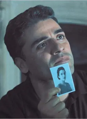  ?? MGM ?? Peter Malkin (Oscar Isaac) shows a picture of his late sister to Adolf Eichmann (Ben Kingsley) in hopes of making a connection in “Operation Finale.”
