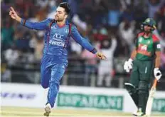  ?? AFP ?? ■ Afghanista­n ‘s Rashid Khan celebrates after claiming a Bangladesh wicket during the first T20 match in Dehradun.