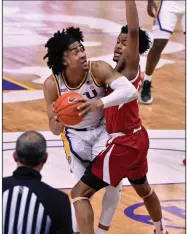  ?? (AP/The Advocate/Hilary Scheinuk) ?? LSU forward Trendon Watford (left) tries to move past Arkansas guard Moses Moody during the Tigers’ victory over the Razorbacks on Wednesday in Baton Rouge. Watford had 23 points on 9-of-16 shooting with 10 rebounds.