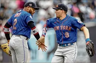  ?? Adam Hunger / Associated Press ?? Brandon Nimmo (9) and Dominic Smith celebrate the Mets’ win over the Yankees on Saturday. They had three hits each with Smith adding three RBIS in the rout.