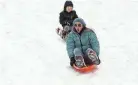  ?? ?? March 5, 2015: Leah Keys flies down the hill at the Levitt Shell in Overton Park, cutting off son Hopper Harmon. The popular hill was packed with families enjoying the winter weather and snow day from school.