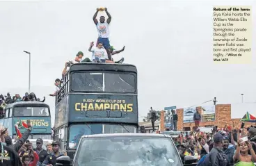  ?? /Wikus de Wet/AFP ?? Return of the hero: Siya Kolisi hoists the William Webb Ellis Cup as the Springboks parade through the township of Zwide where Kolisi was born and first played rugby.