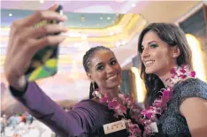  ??  ?? SAFE SMILES: Miss Jamaica Sanneta Myrie snaps photos with Miss Poland Marta Kaja Palucka at the opening of the Miss World Competitio­n in Sanya, China.