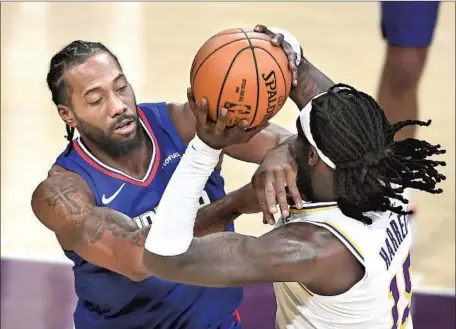  ?? Photog r aphs by Wally Skalij Los Angeles Times ?? KAWHI LEONARD fouls the Lakers’ Montrezl Harrell, who caught a little f lak from his former Clippers teammates, in the f irst quarter at Staples Center. Harrell f inished with 13 points and 12 rebounds in 31 minutes of his Lakers debut, and pro basketball’s return to L. A.