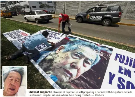  ?? — Reuters ?? Show of support: Followers of Fujimori (inset) preparing a banner with his picture outside Centenario Hospital in Lima, where he is being treated.