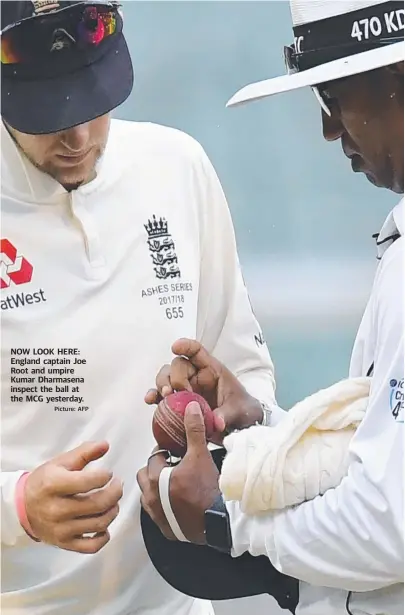  ?? Picture: AFP ?? NOW LOOK HERE: England captain Joe Root and umpire Kumar Dharmasena inspect the ball at the MCG yesterday.