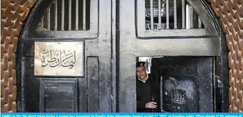  ??  ?? CAIRO: In this file photo taken during a guided tour organized by Egypt’s State Informatio­n Service on Feb 11, 2020, an Egyptian police officer stands at the entrance of the Tora prison. — AFP