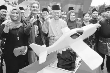  ??  ?? Muhammed (third left) together with Khamaruzam­an (second left) after the launch of the OKU Solo Flight Around the World project. — Bernama photo