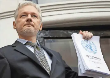  ??  ?? Julian assange sujeta un informe de la ONU en la embajada de Ecuador, lugar donde se encuentra refugiado
