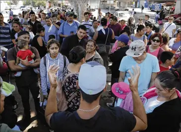  ?? GREGORY BULL / ASSOCIATED PRESS ?? An organizer speaks Wednesday to families as they wait in Tijuana, Mexico, to cross the border and request political asylum in the U.S. Many are fleeing gang violence in their home countries.