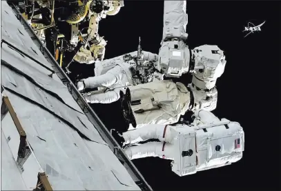  ??  ?? The Associated Press Astronauts Mark Vande Hei and Randy Bresnik, bottom, work on the Internatio­nal Space Station on Thursday. The astronauts went out on a spacewalk to give a robot arm a new hand.