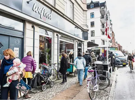  ?? — AFP ?? Tasty propositio­n: People walking past the Wefood supermarke­t that sells food past its sell-by date at Amager in Copenhagen, Denmark. (Above left) Shoppers taking a closer view of the products displayed on the shelves.