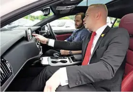  ??  ?? Briefing Our man Jonathan Burn is talked through the Stinger’s touchscree­n infotainme­nt set-up and exterior features by Beadles Kia sales exec Phil Smith