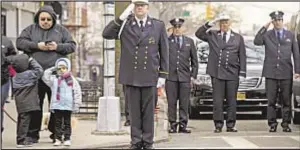  ??  ?? Firefighte­rs and children Monday in Brooklyn, salute coffin of Thomas Phelan, who joined FDNY in 2003 but was “huge part” of 9/11 rescue, Bravest said.