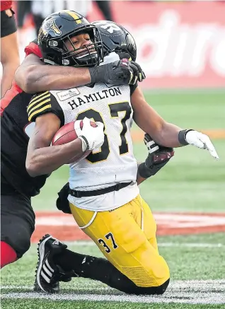  ?? JUSTIN TANG THE CANADIAN PRESS ?? Hamilton’s Frankie Williams gets hauled down by Ottawa’s Josue Matias on a kick return in Sunday’s CFL East Division final — in which almost nothing bounced the Tiger-Cats’ way.