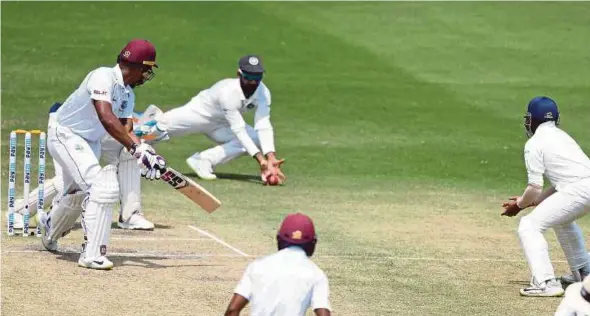  ?? AFP PIC ?? West Indies’ Kieran Powell (left) looks on as India’s Ajinkya Rahane successful­ly catches the ball in the slips during the third day of their second Test match on Sunday.