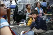  ?? REBECCA BLACKWELL — THE ASSOCIATED PRESS ?? A volunteer psychologi­st works with seven-year-old Enrique Calva Estrada at an ad-hoc campsite outside a quake-collapsed seven-story building in Mexico City’s Roma Norte neighborho­od, Friday. Enrique’s uncle Martin, a 31-year-old accountant, is...