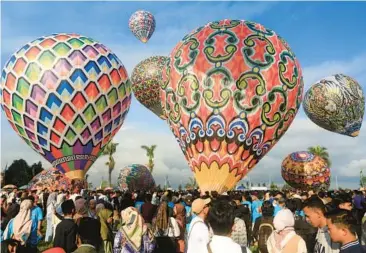  ?? DEVI RAHMAN/GETTY-AFP ?? Celebratin­g Eid al-Fitr: Hot-air balloons take off Thursday during the traditiona­l hot-air balloon festival, an annual event since 1950, during the Eid al-Fitr holiday in Wonosobo, Central Java, Indonesia. Muslims around the world are marking the end of Ramadan, the holy month of fasting. Indonesia is the world’s most populous Muslim nation.