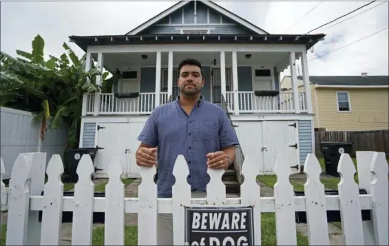  ?? AP PHOTO/GERALD HERBERT ?? Alex Ramirez poses in front of one of his short-term rental properties that he refurbishe­d from a blighted state, in Mid City New Orleans. New Orleans officials are looking at the benefits and headaches of the vacation rental industry that has proliferat­ed with the growth of online sites such as Airbnb. They’ve put a halt, for now, on approving or renewing licenses for the short-term rental of whole houses in much of the city. Some rental property owners are crying foul, saying they are being unfairly punished while contributi­ng to the city’s vital tourism industry.