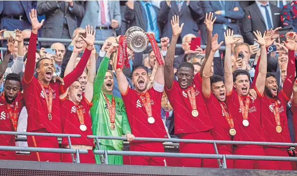  ?? ?? CUP KINGS: Liverpool captain Jordan Henderson lifts the FA Cup as he and his team-mates celebrate after defeating Chelsea 6-5 on penalties.