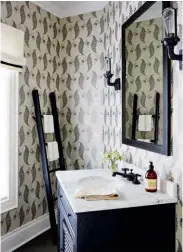  ??  ?? TOP LEFT A pretty patterned wallpaper distracts from this powder room’s awkward angles. Using the space’s drawbacks to her advantage, Jessica leaned a vintage wooden ladder against the wall to hang towels for guests.
