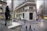  ?? MARK LENNIHAN — THE ASSOCIATED PRESS FILE ?? People walk to work on Wall Street beneath a statue of George Washington, in New York. Big-name companies notched gains on Wall Street Tuesday, delivering more records for two of the major stock indexes.