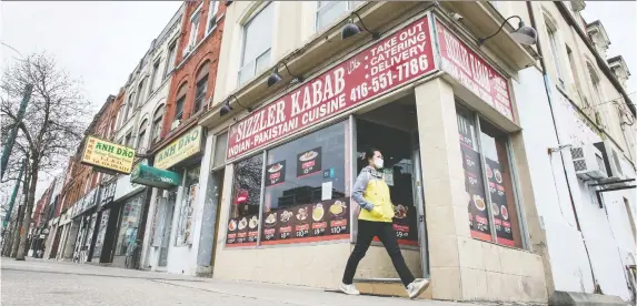  ?? PETER J. THOMPSON ?? A pedestrian walks past closed or take-out only restaurant­s in Toronto’s Chinatown last week. Grim numbers, including more than 40 per cent of Canadian businesses that have laid off staff, illustrate the damage from COVID-19 shutdowns. At the same time, the Business Barometer, which measures small business confidence, rose nine points to 46.4 in April.