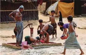  ?? REUTERS PIC ?? Rohingya children taking bath and collecting water from a tubewell at Balukhali makeshift refugee camp in Cox’s Bazar, Bangladesh on Sunday.