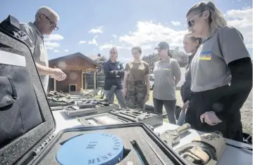  ?? VISAR KRYEZIU AP ?? Demining instructor Artur Tigani, left, briefs a group of Ukrainian female emergency services personnel for specialist training in explosive ordnance disposal and survey training in the western Kosovo city of Peja on April 25. Six Ukrainian women are training in Kosovo to dispose of explosive ordnance that have contaminat­ed their country invaded by Russia.