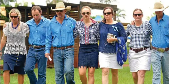  ?? PHOTO: MICHAEL FRANCHI ?? HEART BREAK: Tick Everett, Meg Everett, and Kate Everett (centre three) surrounded by family at Casuarina Street primary school after Dolly Everett's memorial service in Katherine, Northern Territory.