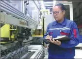  ?? PROVIDED TO CHINA DAILY ?? NPC deputy Xu Yanni inspects engine parts at a factory of Yuchai Group.