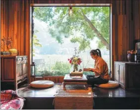  ?? LI BO / XINHUA ?? A visitor reads at a homestay in Suzhou, Jiangsu province.