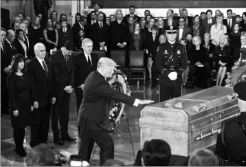  ?? ASSOCIATED PRESS ?? PRESIDENT DONALD TRUMP TOUCHES THE CASKET of Rev. Billy Graham, who died last week at age 99, during a ceremony in the Capitol Rotunda where he will lie in honor as a tribute to America’s most famous evangelist, Wednesday, in Washington.