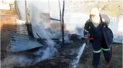  ?? Photo: Sue Maclennan ?? Fire fighter Nombulelo Mkele douses a fire that destroyed a shack in Vergenoeg on Sunday 21 August.