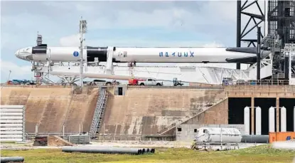  ?? JOE BURBANK/ORLANDO SENTINEL ?? The Space X Demo-2 Falcon 9 rocket, with the Crew Dragon capsule, far left, lies horizontal Tuesday at Kennedy Space Center.