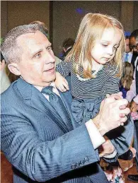  ??  ?? Chad Coleman, 45, of Edmond, holds his daughter, Brooklyn Coleman, 4, as they have fun at the Daddy Daughter Dance.