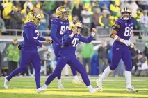  ?? ANDY NELSON/ASSOCIATED PRESS ?? Washington placekicke­r Peyton Henry (47) celebrates with punter Jack McCalliste­r (38), tight end Quentin Moore (88) and long snapper Jaden Green (89) during a 2022 game against Oregon. Both Washington and Oregon will join the Big Ten in 2024.