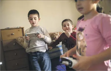  ?? Patrick T. Fallon For The Times ?? TONY ALSABAA, 5, center, plays video games with his cousins Cristian Rebz, 8, left, and Clarissa Rebz, 7, in Santa Clarita last week.