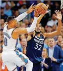  ?? [PHOTO BY NATE BILLINGS, THE OKLAHOMAN] ?? Oklahoma City’s Russell Westbrook, left, passes as Minnesota’s Karl-Anthony Towns defends during the second half of Sunday night’s loss to the Timberwolv­es at Chesapeake Energy Arena.