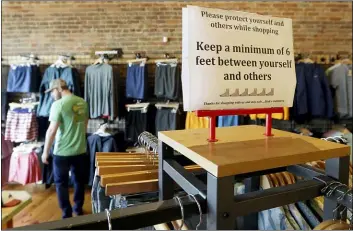  ?? MARK HUMPHREY — THE ASSOCIATED PRESS ?? A sign reminding customers of social distancing is posted in the Bink’s Outfitters store Wednesday, April 29, 2020, in Murfreesbo­ro, Tenn. Retailers in 89of Tennessee’s 95 counties were allowed to reopen Wednesday with restrictio­ns as the state begins the next wave of reopening its economy during the coronaviru­s pandemic.