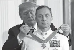  ?? SUSAN WALSH/ASSOCIATED PRESS ?? President Donald Trump awards the Medal of Honor to Master Chief Special Warfare Operator Britt K. Slabinski during a ceremony Thursday in the East Room of the White House. Slabinski oversaw a daring 2002 assault and rescue mission on a snowy...