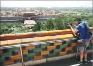  ?? WANG JING / CHINA DAILY ?? A foreign reporter takes photos at a pavilion on Jingshan Mountain overlookin­g the Forbidden City on a media group tour around Beijing in late May.