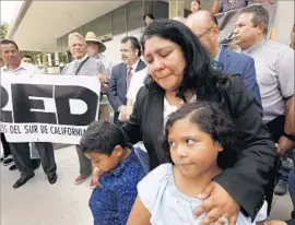  ?? Al Seib Los Angeles Times ?? VICTORIA CARIAS, the wife of Noe Carias, with their two children outside the L.A. Federal Building on Monday during a protest by Latino religious leaders.