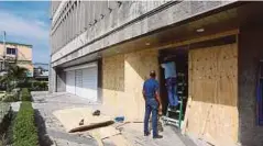  ??  ?? KAKITANGAN sebuah kedai menutup tingkap premis dengan papan lapis sebagai persediaan menghadapi Taufan Irma di Santo Domingo, Republik Dominika. - EPA