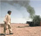  ?? FRAIDOON POOYAA/AP ?? An Afghan boy passes a police vehicle set aflame by protesters during a demonstrat­ion against civilian killings in a U.S. raid in Azizabad, Afghanista­n.