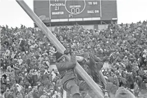  ?? ASSOCIATED PRESS ?? Fans climb on the goal post at Lambeau Field after the Green Bay Packers beat the Dallas Cowboys.