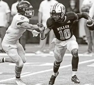  ?? Tom Reel / Staff photograph­er ?? Corpus Christi Miller quarterbac­k Andrew Body avoids a Boerne tackler in the first half. Body threw for 432 yards on 24-of-36 passing with four touchdowns along with a rushing TD.