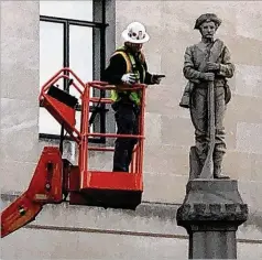  ?? TOM FOREMAN JR. / AP ?? A workman prepares a Confederat­e statue for removal from the grounds of an old courthouse Tuesday in Winston-Salem, N.C.