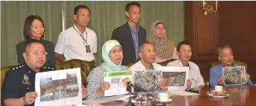  ??  ?? Rodziah (seated second left) and her senior officials and a police officer show the routes of the roads that will be closed.