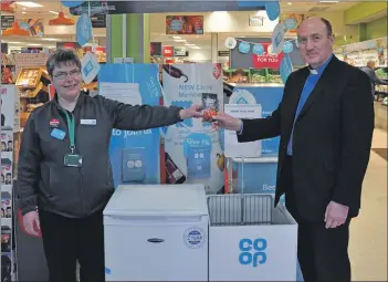  ?? 01B05foodb­ank01 ?? Co-op team manager Carol Harwood presents Rev Angus Adamson with a freezer and savings stamps which have been donated to the Arran Churches Together Foodbank.